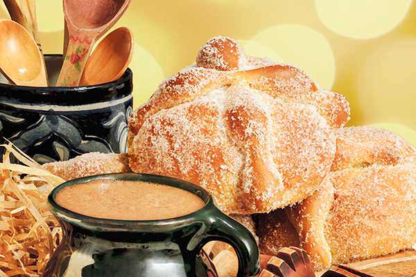 round load of bread(pan de muerto) with a cup of hot chocolate
